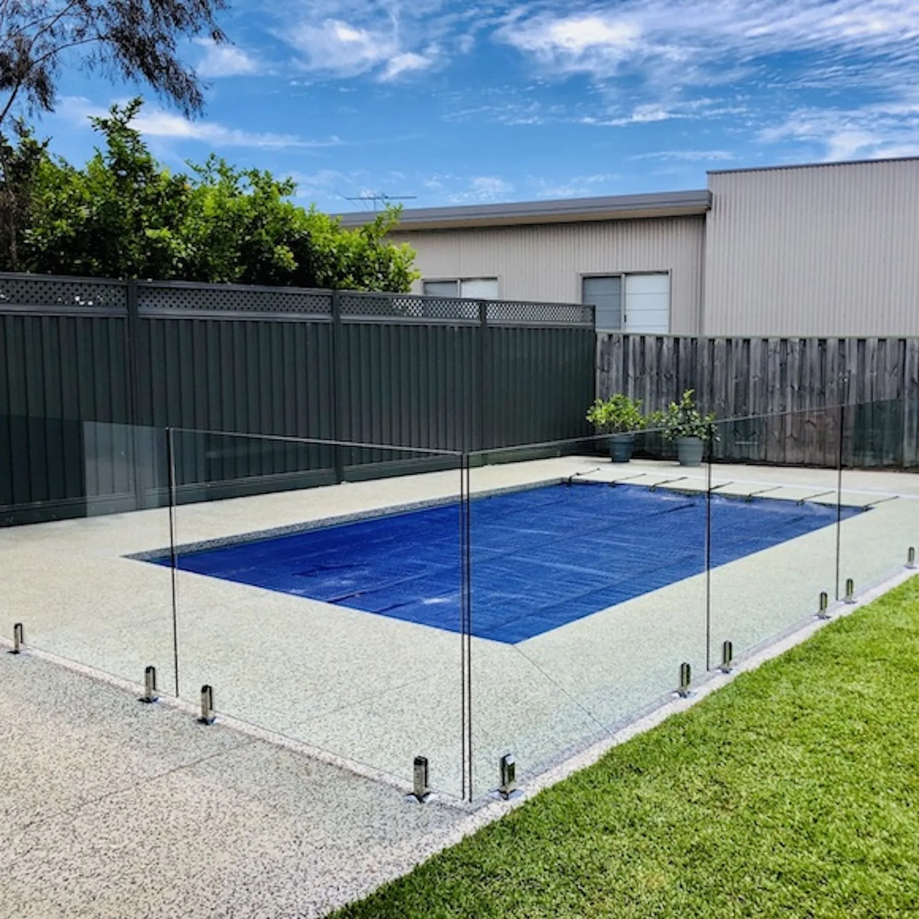 Frameless glass pool fencing around a pool deck