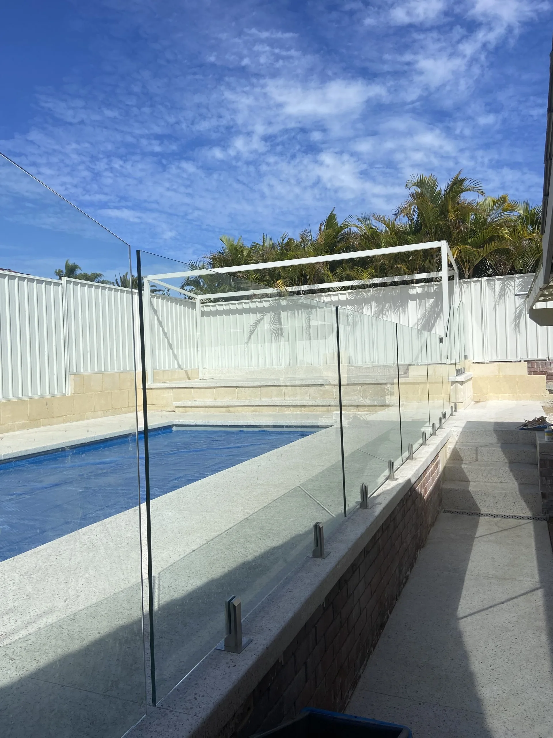 Frameless glass pool fencing along a covered pool