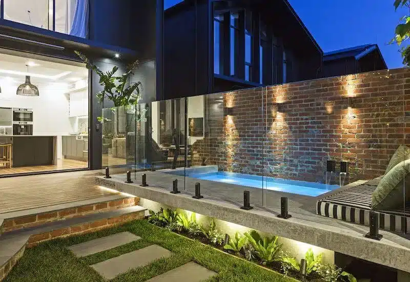 Glass pool fencing around a plunge pool at a modern home at night