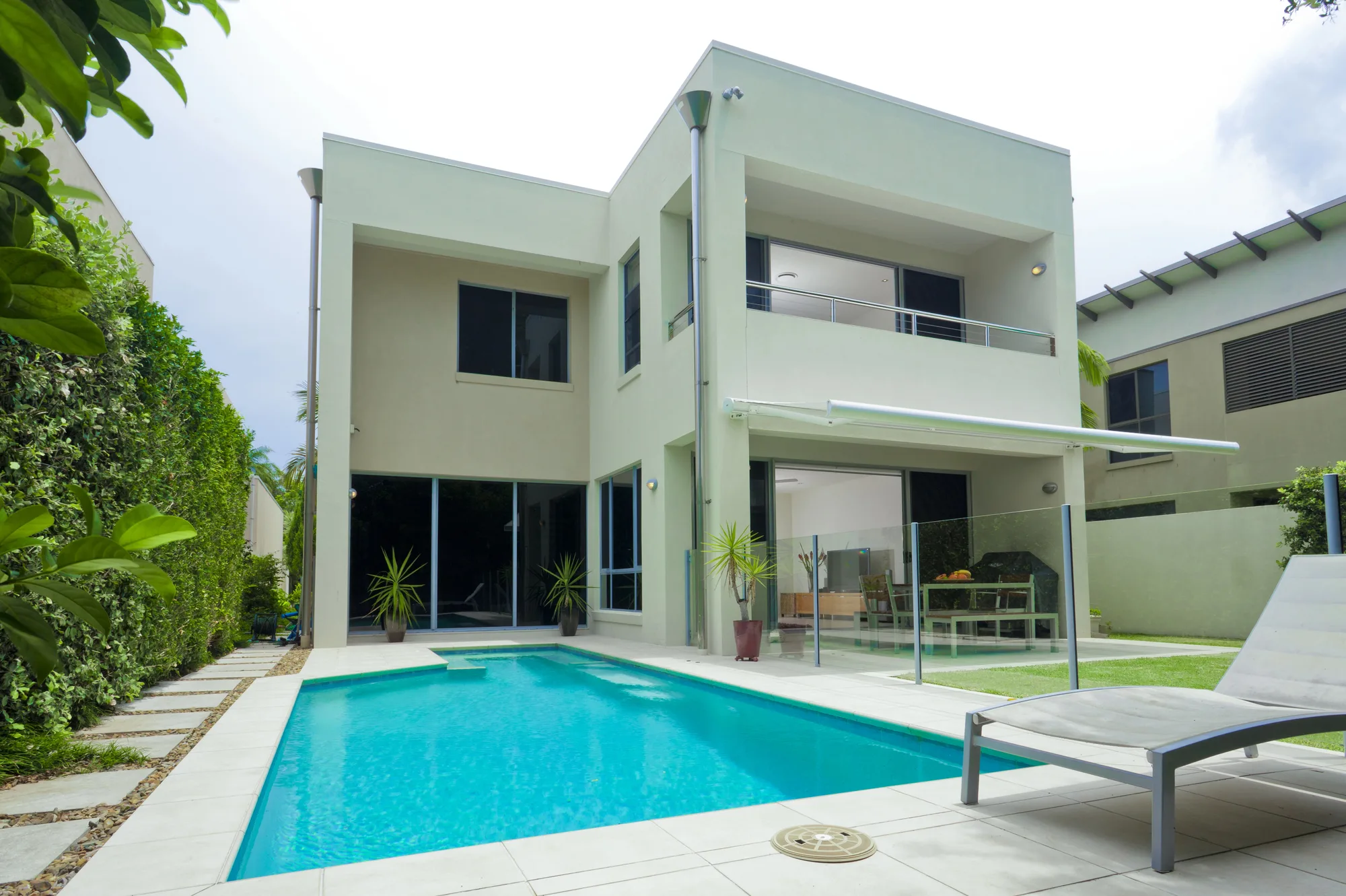 Glass pool fencing around a modern home pool