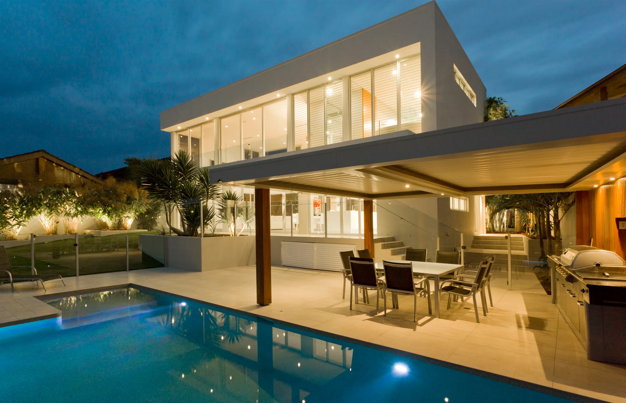 Pool at dusk with a glass balustrade edge