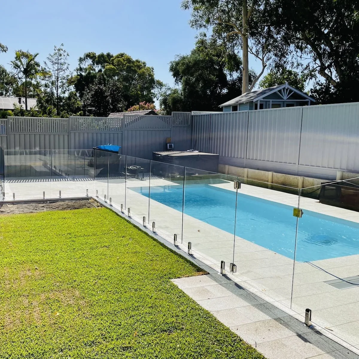 Glass pool fencing being installed around a new pool